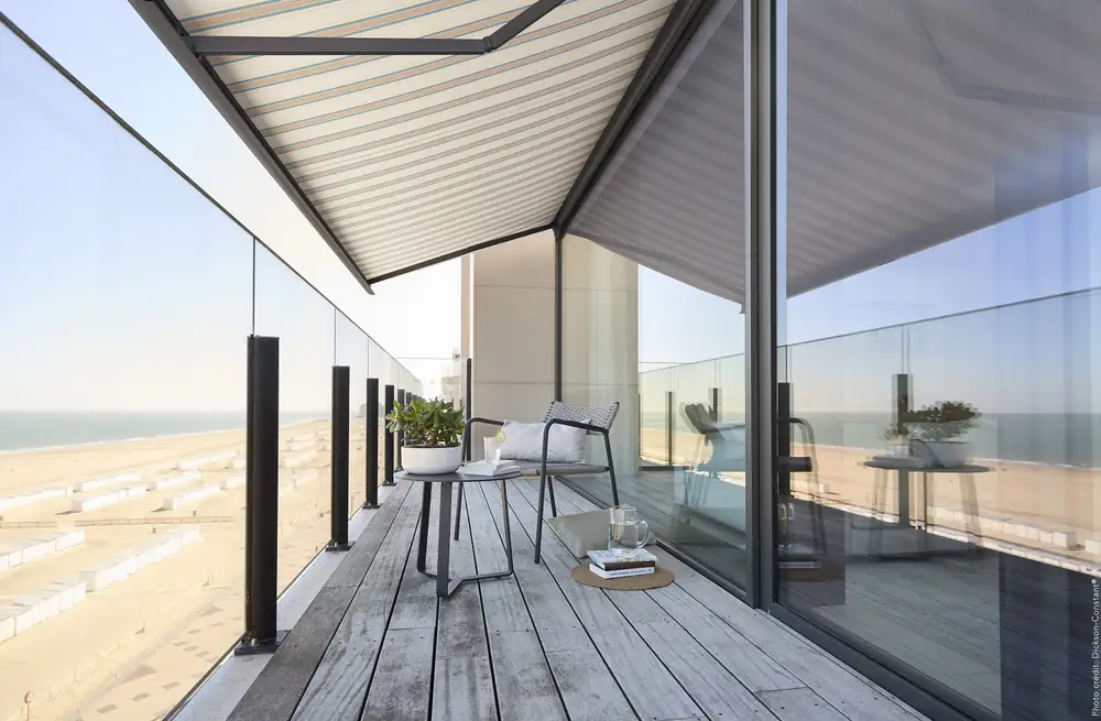 Striped Dickson Orchestra awning over a seaside balcony