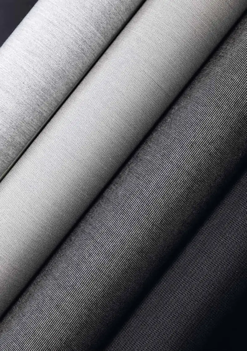 Rolls of Dickson Orchestra solution-dyed acrylic awning fabric in grey tones