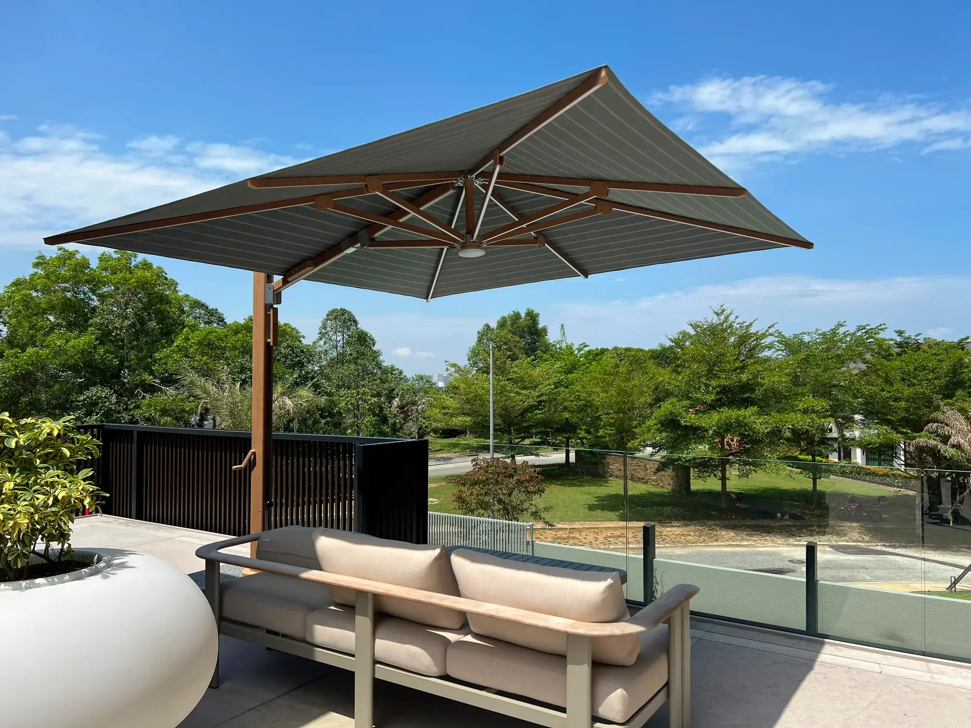 Cantilever parasol with outdoor shade fabric over a rooftop terrace sofa in Malaysia