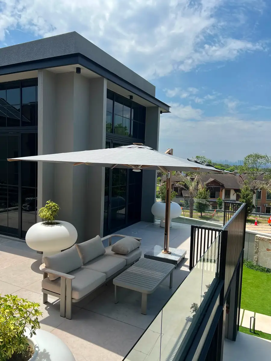 Square cantilever parasol with a grey striped acrylic canopy over an outdoor sofa on a villa terrace